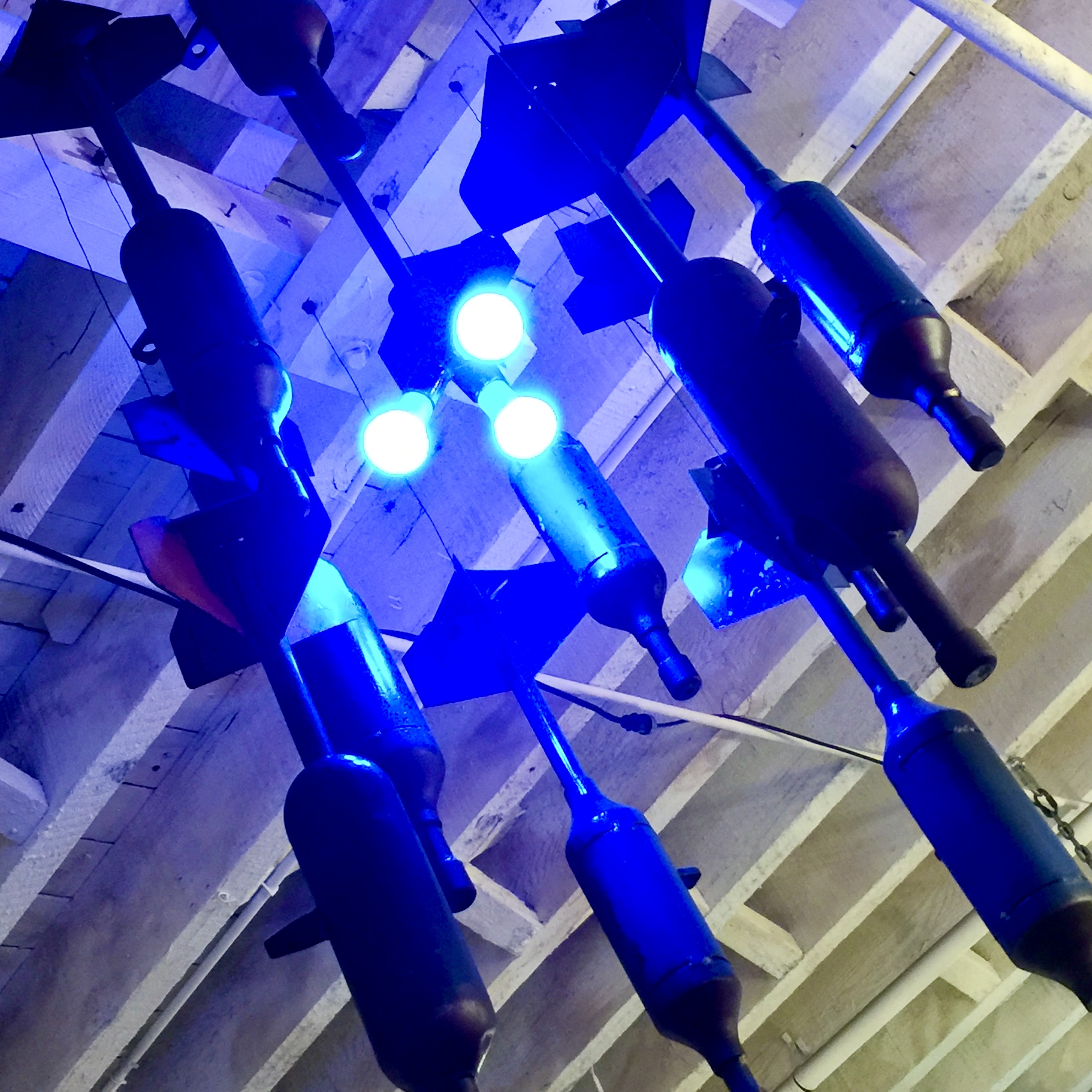 DCLA FAB upcycled military component chandelier with custom blue LED lighting